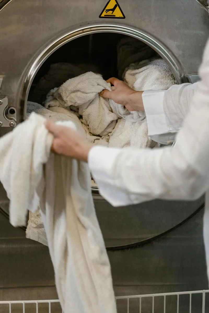 Chargement du linge dans un lave-linge connecté Wi-Fi pilotable depuis smartphone