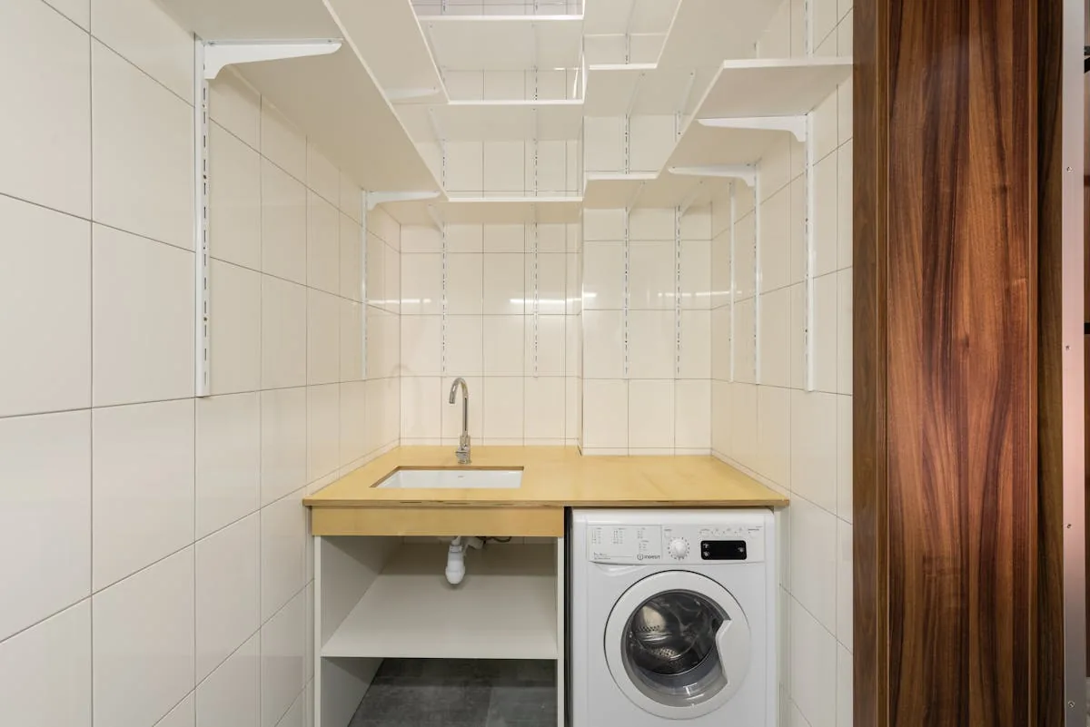 Petite buanderie équipée d'un lave-linge top, format gain de place